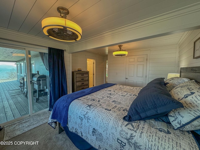 carpeted bedroom featuring crown molding, access to outside, and wood walls