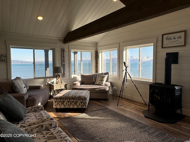 sunroom with plenty of natural light, a water view, and beam ceiling