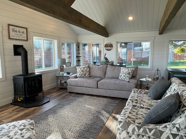 sunroom / solarium with wooden walls, a wood stove, a deck, vaulted ceiling with beams, and wood finished floors
