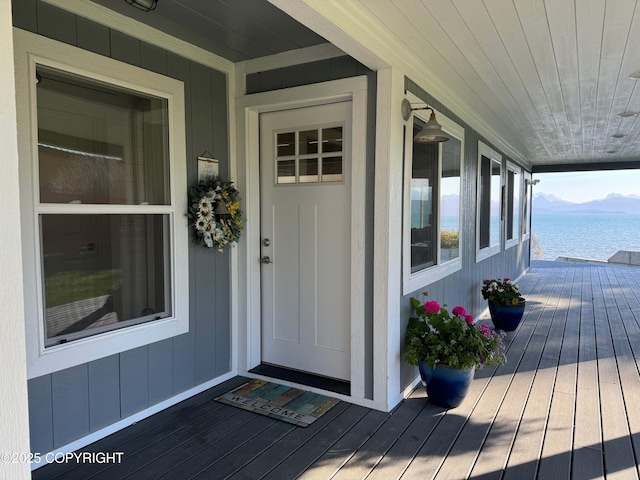 doorway to property featuring a water view and covered porch