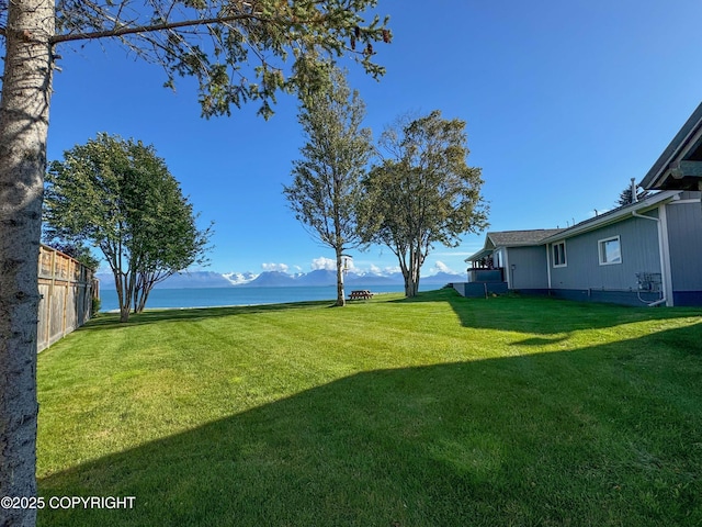 view of yard featuring a water and mountain view and fence