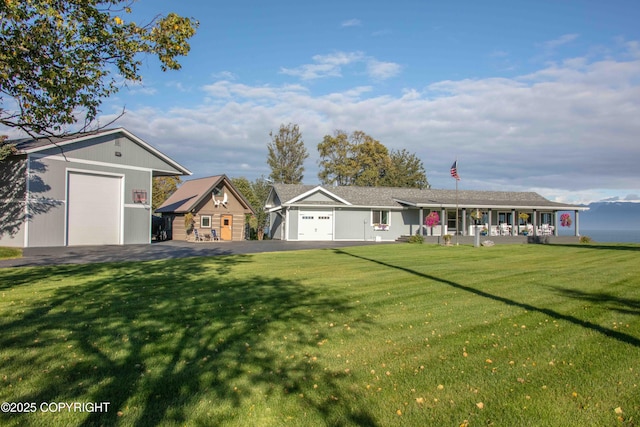 view of front facade with an outbuilding, a porch, and a front lawn