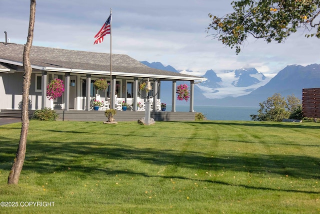 exterior space with a lawn, a mountain view, and a porch