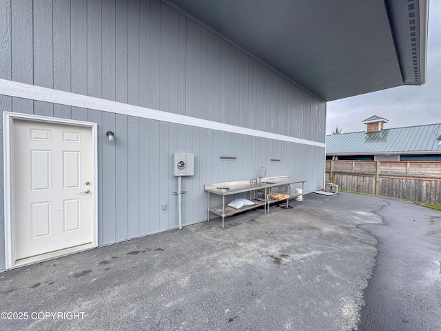 view of property exterior featuring fence and a patio area