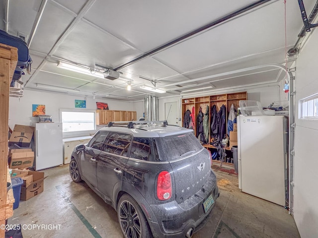 garage with freestanding refrigerator and a garage door opener