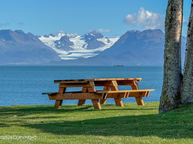 dock area with a yard and a water and mountain view