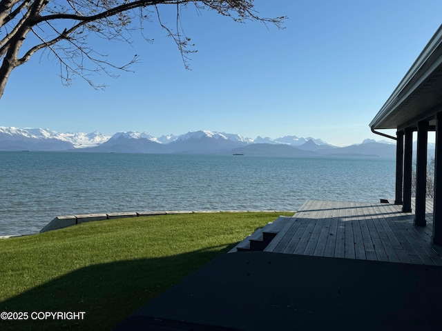 exterior space featuring a lawn and a water and mountain view
