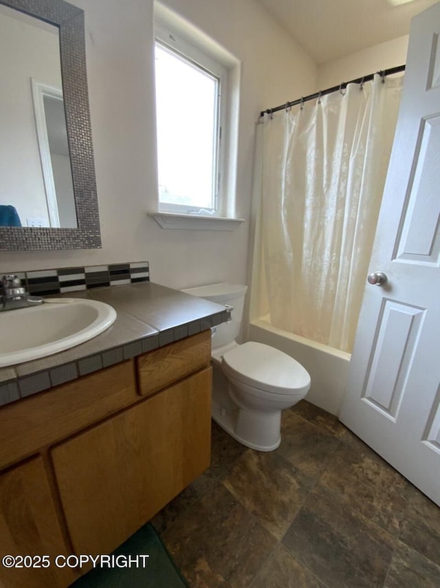full bathroom featuring vanity, shower / bathtub combination with curtain, toilet, and stone finish flooring