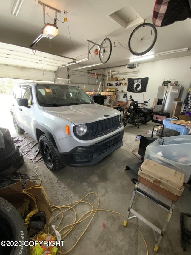garage with stainless steel fridge and a garage door opener