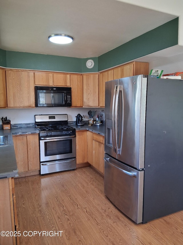 1012 Channel Way, Kenai, AK 99611 - kitchen featuring stainless steel appliances, dark countertops, and light wood-type flooring