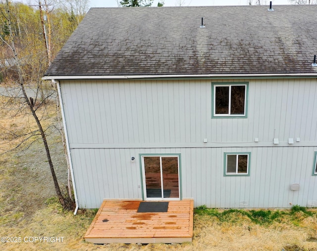 back of house with a wooden deck and roof with shingles