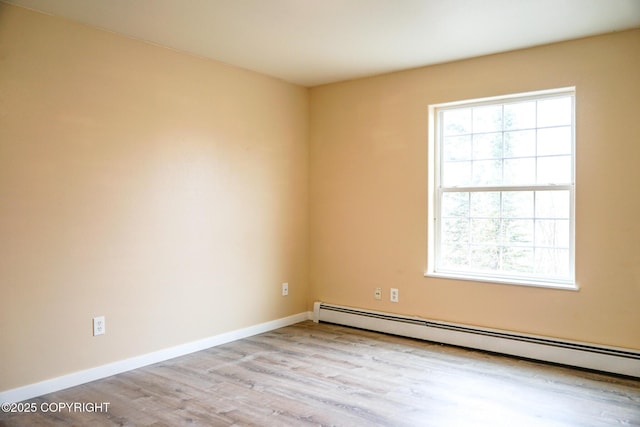 unfurnished room with baseboards, baseboard heating, and wood finished floors