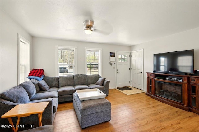 living area with light wood-style flooring and ceiling fan