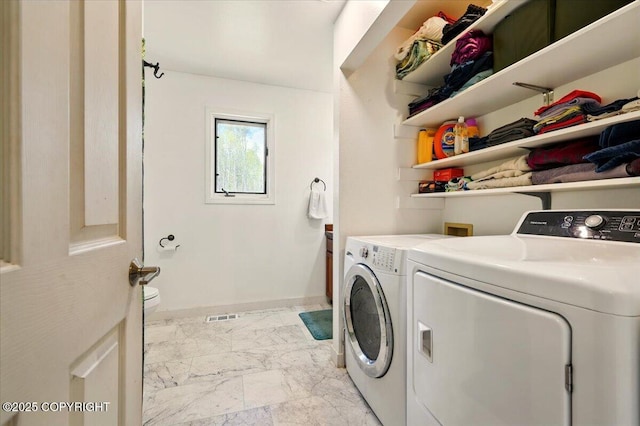 clothes washing area featuring washing machine and dryer, laundry area, marble finish floor, and visible vents