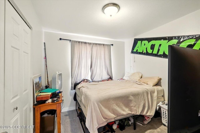 bedroom with a closet, lofted ceiling, and carpet floors
