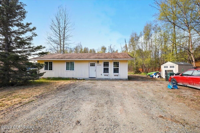 view of front facade featuring a storage shed and an outbuilding