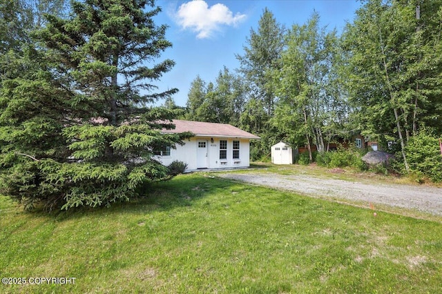 6132 S Northern Lights St, Wasilla, AK 99623 - view of front of home with a storage unit, a front yard, and dirt driveway