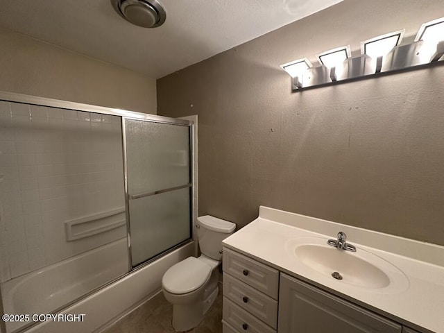 bathroom featuring bath / shower combo with glass door, vanity, and toilet