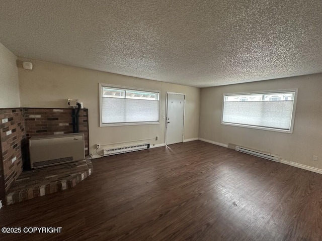 unfurnished living room featuring a textured ceiling, baseboard heating, and wood finished floors