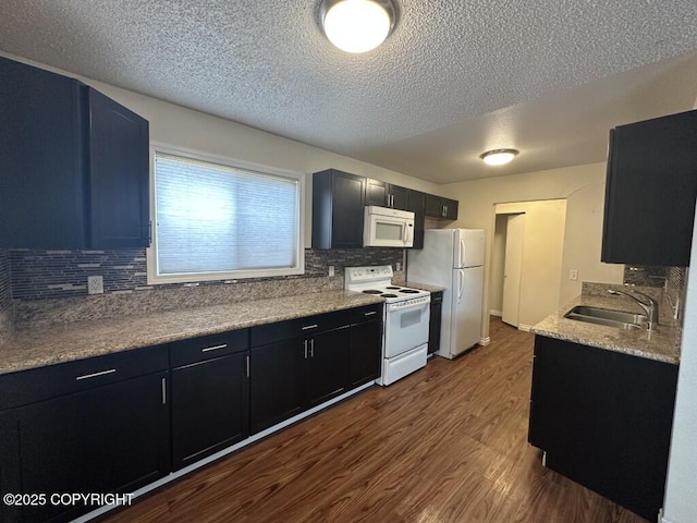 kitchen featuring tasteful backsplash, a sink, white appliances, a textured ceiling, and dark wood-type flooring