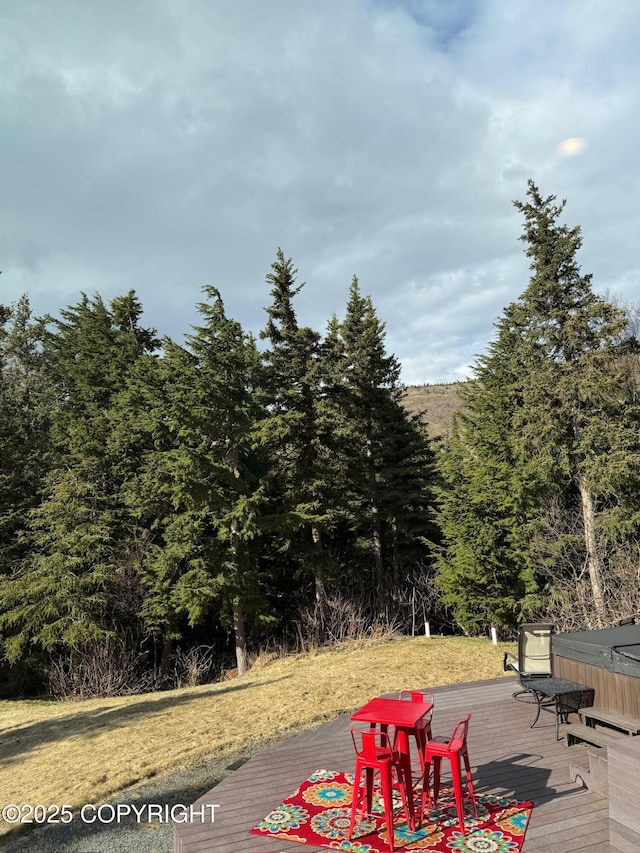 wooden terrace featuring a wooded view