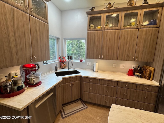 kitchen with a sink, light countertops, and glass insert cabinets
