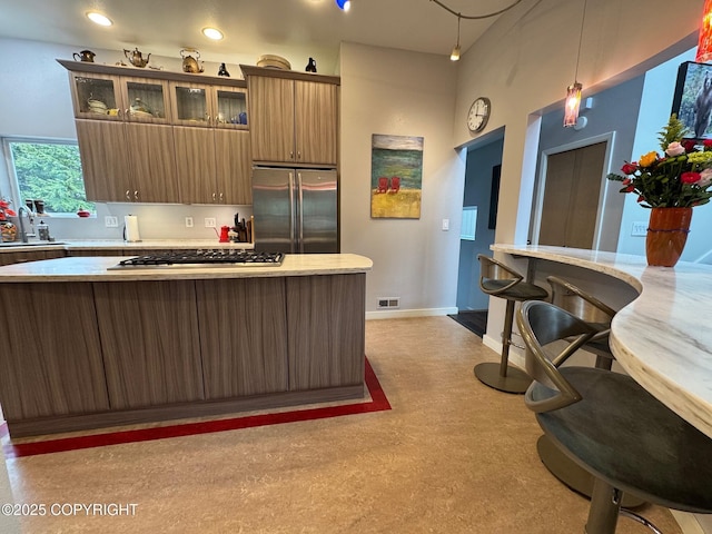 kitchen with visible vents, appliances with stainless steel finishes, light countertops, baseboards, and glass insert cabinets