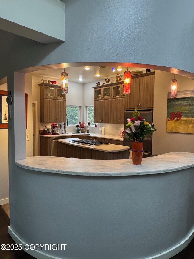 7041 Potter Hts, Anchorage, AK 99516 - kitchen featuring light stone countertops, appliances with stainless steel finishes, brown cabinetry, and glass insert cabinets