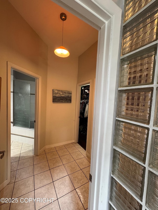 corridor featuring baseboards and tile patterned floors