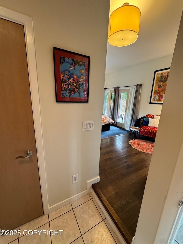 corridor with tile patterned floors and baseboards