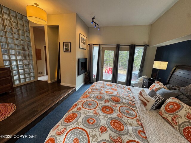 7041 Potter Hts, Anchorage, AK 99516 - bedroom with access to exterior, track lighting, baseboards, dark colored carpet, and dark wood-type flooring