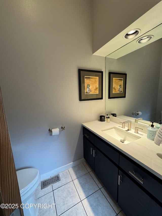 half bath with tile patterned flooring, vanity, toilet, baseboards, and visible vents