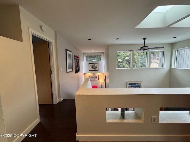 corridor with recessed lighting, a skylight, baseboards, and dark wood-type flooring