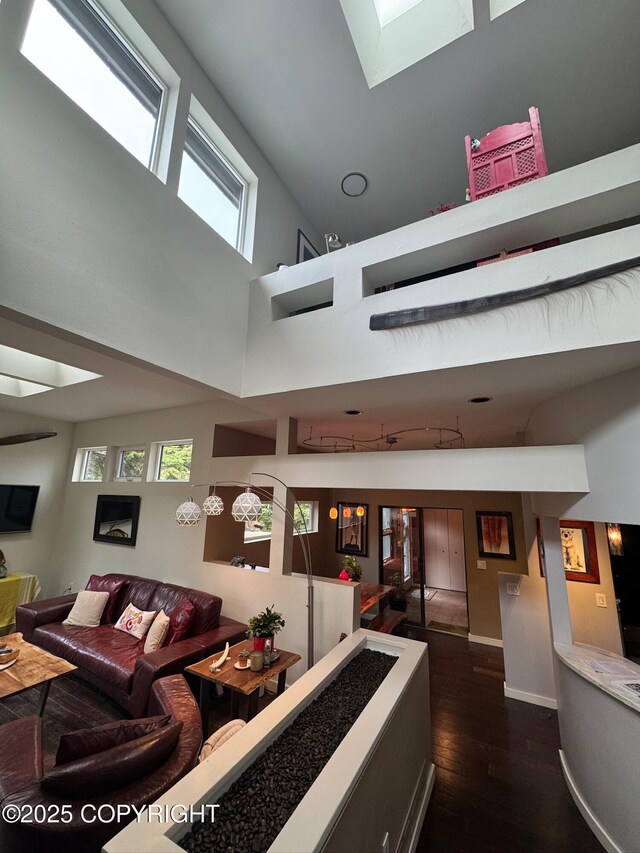 7041 Potter Hts, Anchorage, AK 99516 - living room with dark wood-style flooring, a towering ceiling, a wealth of natural light, and a skylight