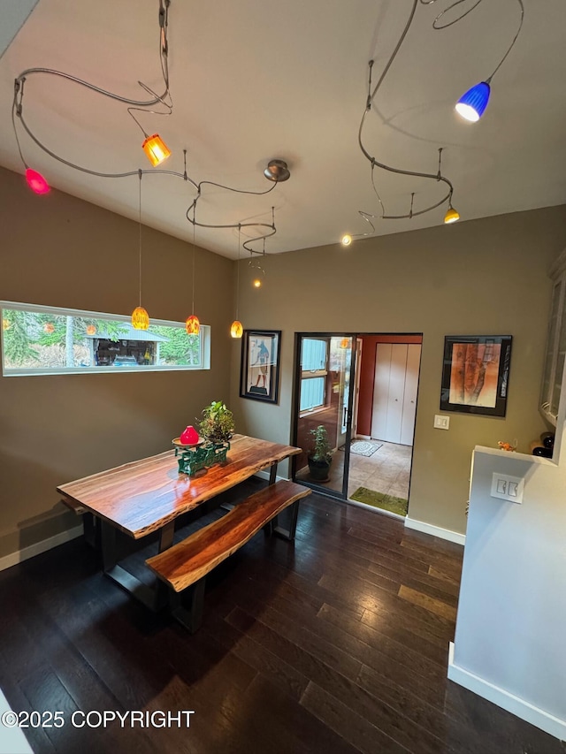 dining space with baseboards and wood-type flooring