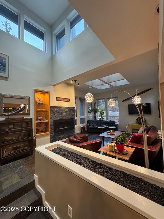 living area with a fireplace and a towering ceiling