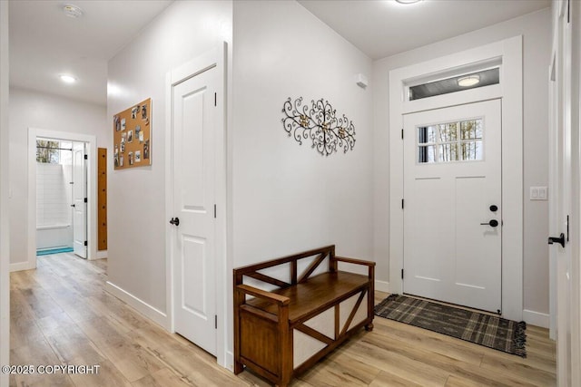 doorway to outside with recessed lighting, baseboards, light wood finished floors, and a healthy amount of sunlight