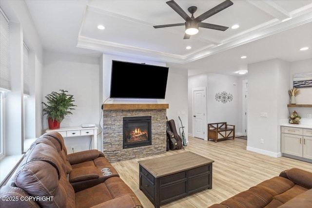 living area with light wood finished floors, a stone fireplace, a ceiling fan, baseboards, and recessed lighting