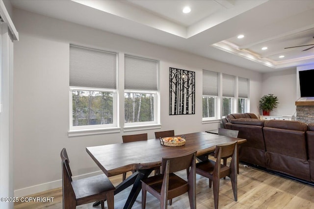dining area with plenty of natural light, recessed lighting, light wood finished floors, and a tray ceiling