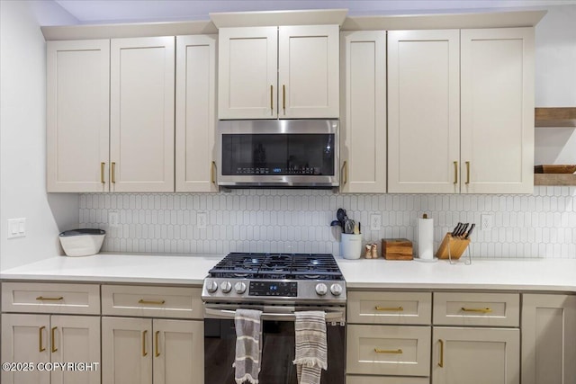kitchen with light countertops, appliances with stainless steel finishes, tasteful backsplash, and open shelves
