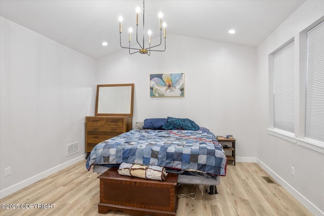 bedroom with visible vents, wood finished floors, and a chandelier