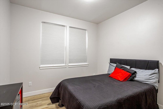 bedroom featuring baseboards and light wood-style flooring