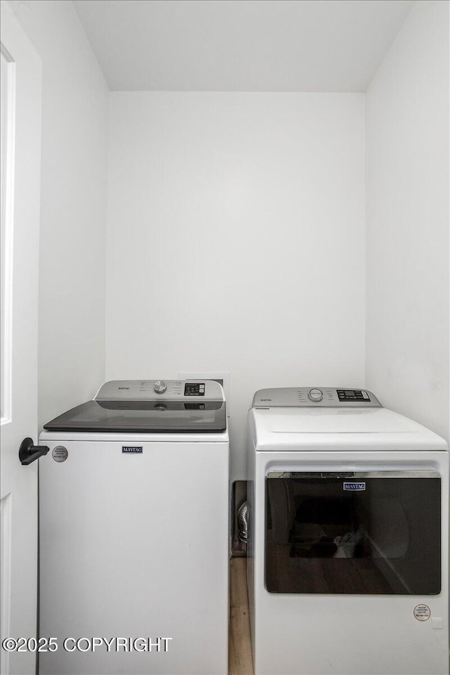 washroom with laundry area, washer and clothes dryer, and wood finished floors
