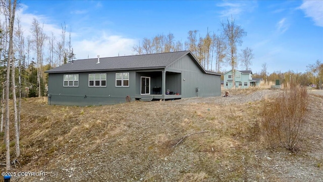 back of house with roof with shingles