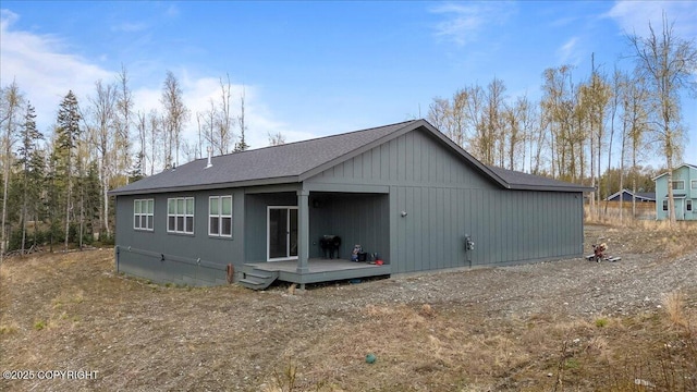 rear view of house with a shingled roof and a deck