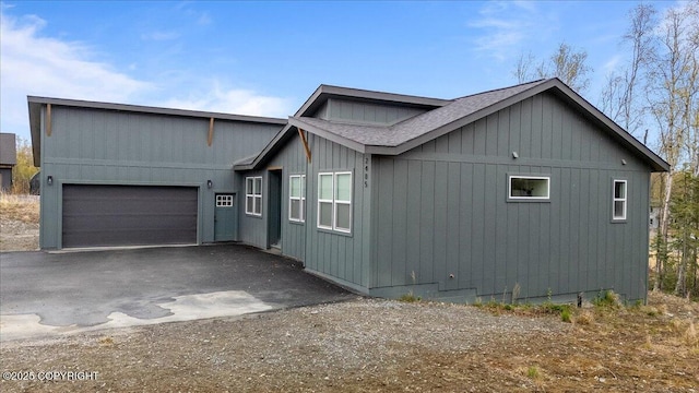 view of front of house featuring a garage, a shingled roof, and aphalt driveway