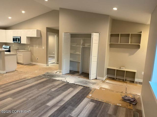 interior space with vaulted ceiling, baseboards, recessed lighting, and light wood-style flooring