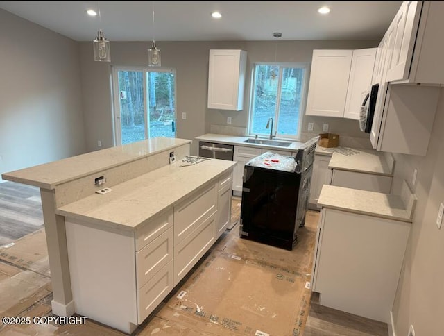 kitchen with a sink, a center island, white cabinetry, recessed lighting, and pendant lighting