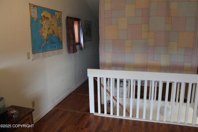 hallway featuring baseboards and wood finished floors