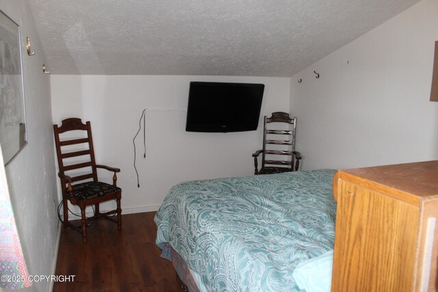 bedroom with baseboards, a textured ceiling, and wood finished floors